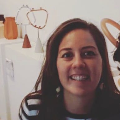 Een lachende vrouw met bruin haar die poseert voor een foto.