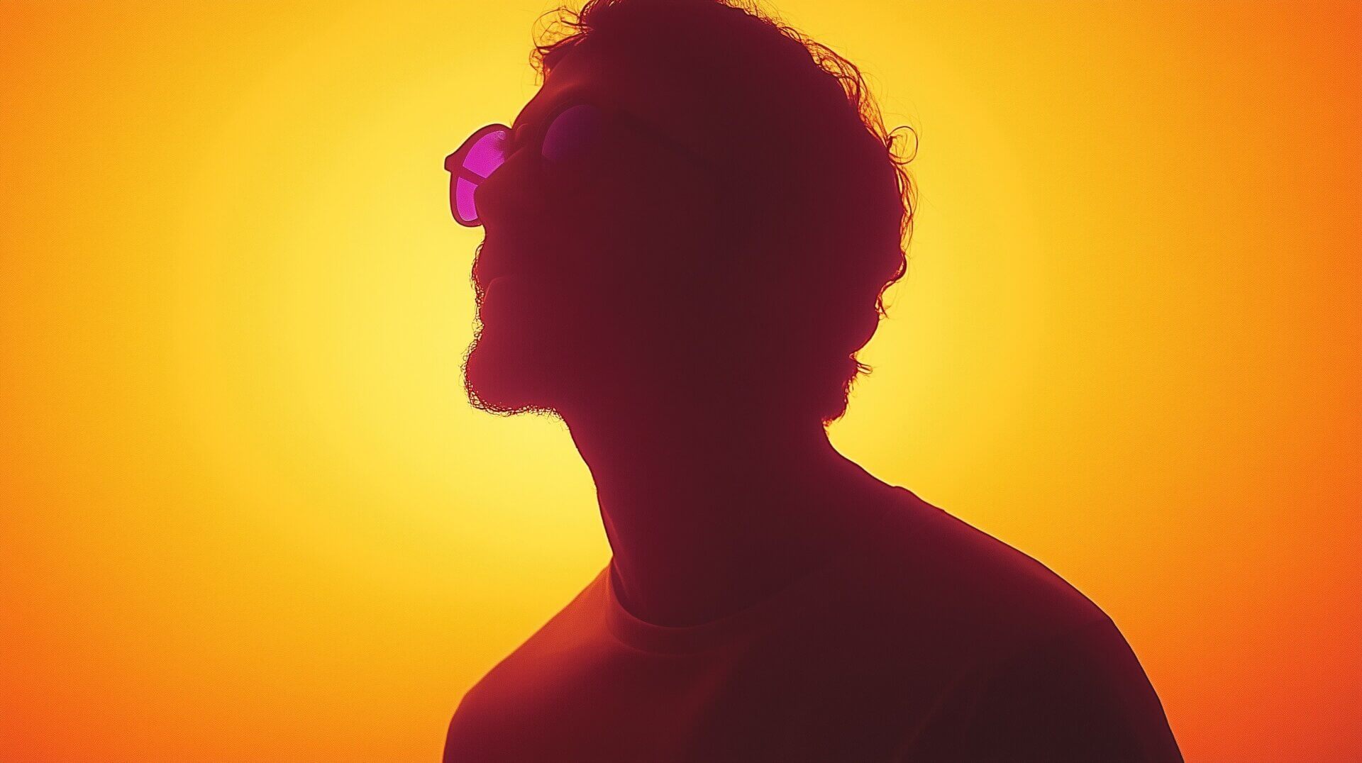 Silhouet van een persoon met krullend haar en een bril, die omhoog kijkt tegen een levendige geeloranje achtergrond die doet denken aan een LinkedIn Video Tab-miniatuur. De belichting creëert een dramatisch halo-effect rond het hoofd.